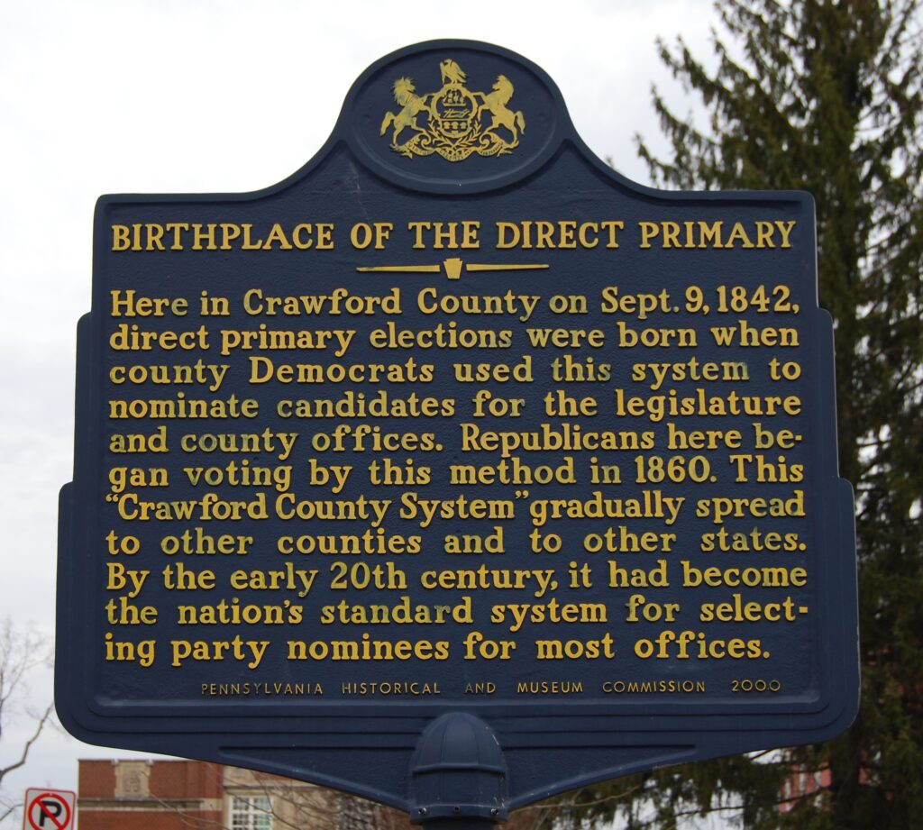 Birthplace of the Direct Primary Sign
Here in Crawford County on Sept. 9, 1842, direct primary elections were born when county Democrats used this system to nominate candidates for the legislature and county offices. Republicans here began voting by this method in 1860. This "Crawford County System" gradually spread to other counties and to other states. By the early 20th century, it had become the nation's standard system for selecting party nominees for most offices.