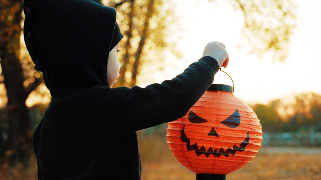 Child holding a pumpkin bucket